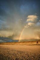 arcobaleno al di sopra di spiaggia nel Danimarca dopo pioggia foto