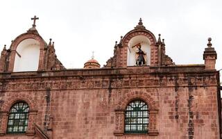 cusco, Perù, 2015 - statua con fiammeggiante spada su tetto di Chiesa Sud America foto