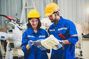 ingegneri squadra meccanico utilizzando computer controllore robotica braccio per saldatura acciaio nel acciaio fabbrica officina. industria robot programmazione Software per automatizzato produzione tecnologia foto