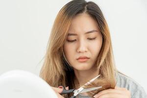 asiatico donna molto triste e irritato guardare a danneggiato capelli, capelli perdita, capelli diradamento problema, vitamina carenza, calvizie, postpartum, biotina, zinco, mestruale o endocrino disturbi, ormonale squilibrio foto