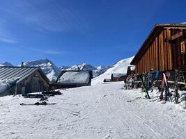 un' sciare casetta con sci e snowboard su il terra foto