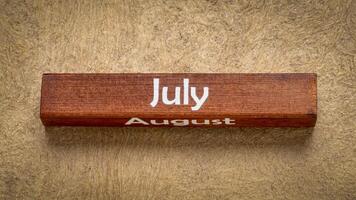 luglio e agosto testo su di legno bloccare contro fatto a mano abbaiare carta nel terra toni, calendario concetto foto
