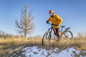 anziano maschio ciclista su un' montagna bicicletta, inverno scenario nel forte collins, Colorado foto