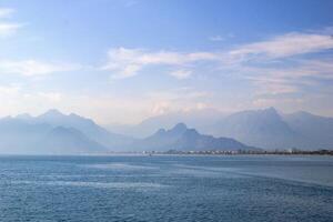 tranquillo paesaggio marino con lontano montagna gamma, chiaro blu cielo, e sereno atmosfera foto