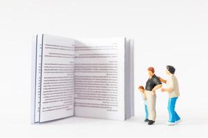 mondo libro giorno concetto, miniatura persone contento famiglia lettura un' libro foto