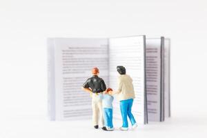 mondo libro giorno concetto, miniatura persone contento famiglia lettura un' libro foto