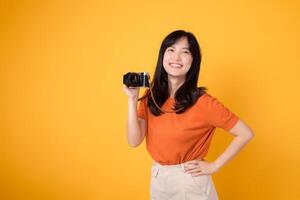simpatico giovane donna con un' telecamera isolato su giallo sfondo, cattura il essenza di un' contento vacanza viaggiatore. foto