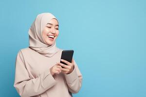 ai generato carino giovane asiatico ragazza nel hijab Tenere un' smartphone nel davanti di un' vivace blu sfondo foto