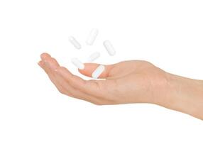 bianca pillole librarsi sopra femmina mano isolato su bianca sfondo. foto