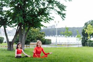 donna e bambino fare yoga nel il parco. estate, sole, madre e figlia, Salute. all'aperto gli sport. salutare sport stile di vita. fitness, yoga foto