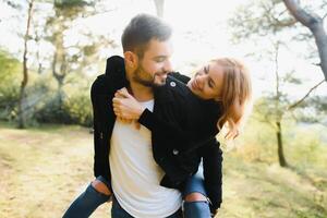 amore, relazione, famiglia e persone concetto - sorridente coppia avendo divertimento nel autunno parco. foto