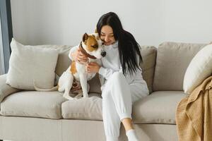 giovane donna con sua carino cane a casa. bello animale domestico. foto