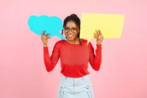 il tuo testo qui. eccitato afro ragazza Tenere vuoto vuoto tavola isolato al di sopra di pastello rosa studio parete, copyspace. foto