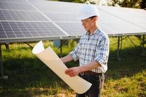 solare energia pianta. uomo in piedi vicino solare pannelli. rinnovabile energia. foto