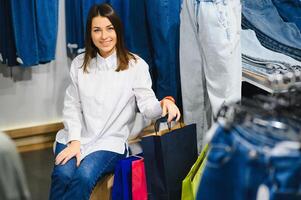 bellissimo femmina guardare jeans nel il boutique foto