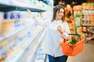 casuale donna drogheria shopping e guardare contento foto