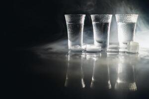 Vodka nel tiro bicchieri su buio sfondo foto