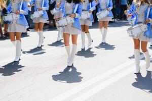 majorette con bianca e blu uniformi eseguire nel il strade di il città. fotografico serie foto