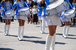 majorette con bianca e blu uniformi eseguire nel il strade di il città. fotografico serie foto