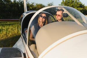 giovane donna e pilota nel nel il cabina di pilotaggio di un' aereo. davanti Visualizza foto