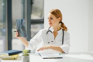 ritratto di attraente femmina medico Tenere appunti mentre in piedi nel clinica. foto