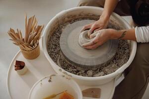 vicino su di mani di professionale vasaio modanatura pentola forma su ceramica ruota. ceramica arte concetto foto