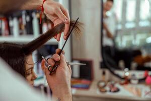 vicino su di estetista mani con un' pettine taglio capelli di donna foto