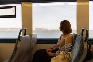 donna nel cuffie mentre in viaggio nel pubblico trasporto e guardare Visualizza al di fuori il finestra foto