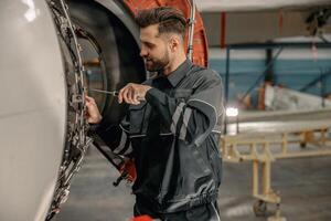 maschio aviazione meccanico riparazione aereo nel hangar foto