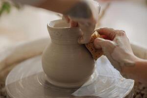 vicino su di mani di professionale vasaio modanatura pentola forma su ceramica ruota. ceramica arte concetto foto