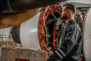 barbuto uomo aviazione meccanico Lavorando nel hangar foto