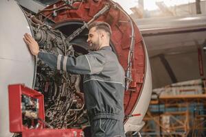 gioioso maschio meccanico riparazione aereo nel hangar foto