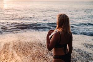 un' ragazza a tramonto su il spiaggia vicino il scogliere di acantilados de los gigantes a tramonto, tenerife, Spagna. foto