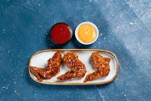 croccante pollo Ali con ketchup e mayo tuffo servito nel piatto isolato su sfondo superiore Visualizza foto