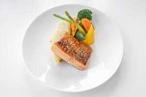 grigliato salmone con insalata servito nel un' piatto isolato su grigio sfondo superiore Visualizza foto
