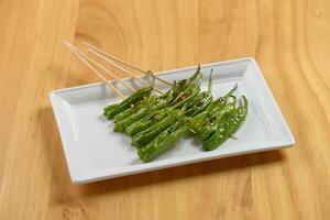 giapponese cibo ocra nel un' bianca vassoio isolato su di legno tavolo superiore Visualizza foto