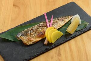 giapponese cibo grigliato saba pesce shioyaki con lime nel un' piatto isolato su di legno sfondo superiore Visualizza foto