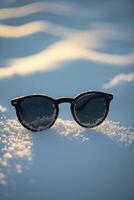 ai generato occhiali da sole su neve foto