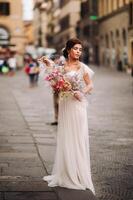 il ragazza-sposa è con bellissimo fiore modello come un' maschera nel Firenze, elegante sposa nel un' nozze vestito in piedi con un' maschera nel il vecchio cittadina di Firenze. modello ragazza nel Firenze foto