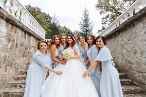 nozze fotografia. un' brunetta sposa nel un' bianca vestito con un' mazzo e sua brunetta amiche foto