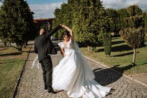 danza contento sposa e sposo nel natura. il maggior parte bellissimo giorno di loro vite. giovane nozze coppia godendo romantico momenti al di fuori nel estate parco foto