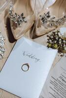 elegante nozze anelli. lettere a partire dal il sposa e sposo. promesse Fidanzamento. lusso matrimonio e nozze accessorio concetto. Due nozze anelli e un' nozze invito foto