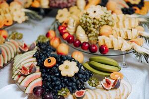 un' banchetto tavolo pieno di frutta e frutti di bosco, un assortimento di dolci. banane, uva, ananas. frutta composizioni per il vacanza. foto