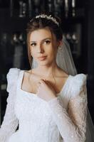 il sposa tocchi il pendente su sua collo con sua dita. preparazione per il nozze. nozze celebrazione. foto