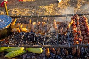 delizioso bbq kebab e polli grigliate su Aperto griglia. foto