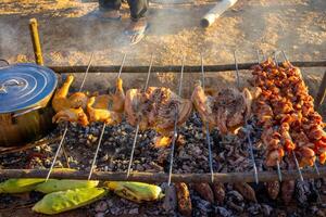 delizioso bbq kebab e polli grigliate su Aperto griglia. foto