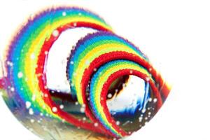 ottico astratto sfondo di arcobaleno tessuto con nodi e leggero effetti nel acqua gocce. foto