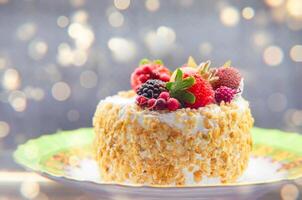 torta coperto con frutti di bosco contro un' d'oro bokeh sfondo. foto