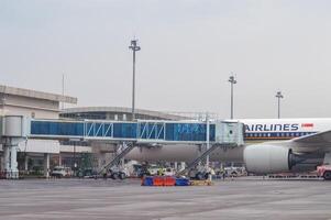 paesaggio di terminale 2 di Juanda internazionale aeroporto quale è attrezzata con un' moderno imbarco ponte con parecchi aerei parcheggiata su il grembiule, Indonesia, 6 gennaio 2024 foto