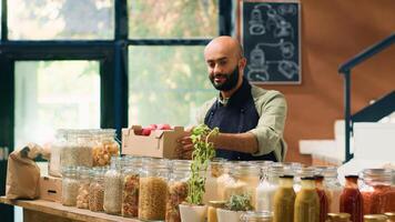 venditore regali appena raccolto mele per diverso coppia nel Locale zero rifiuto eco negozio, clienti supporto biologico agricoltura per un' sostenibile stile di vita. magazziniere mostrando maturo fresco frutta. foto